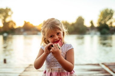 Günbatımında bir dilim karpuz yeme bir güzel kız portresi kapatın.