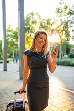 Cep telefonunuzun ve açık havada genç gülümseyen bir kadın portresi.