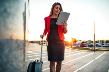 Güzel iş kadını tablet duran bir havaalanı üzerinde kullanma.