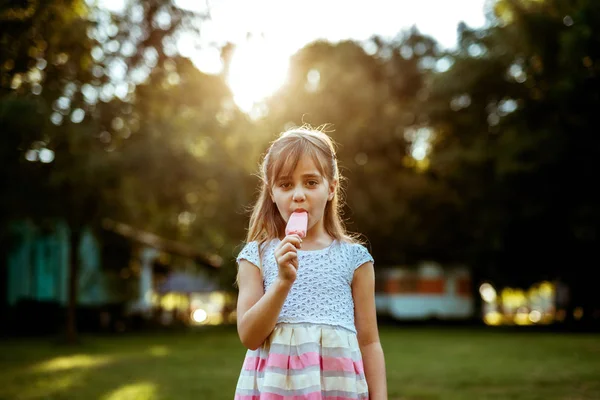 屋外アイス クリームを食べる幸せとかわいい女の子 — ストック写真