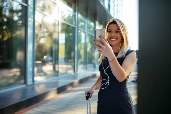 素敵な若いビジネス女性空港で立っていると 携帯電話を使用してのショット — ストック写真