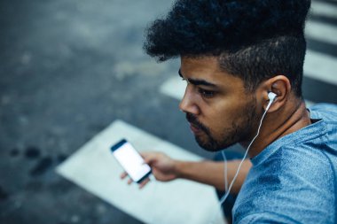 Cep telefonu kullanan bir Afro-Amerikan atlet adam fotoğrafı.