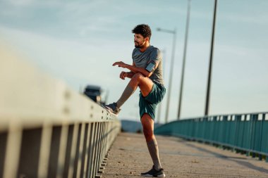 Köprü'ye uzanan sporcu adam.