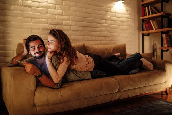 Young Couple Lying Sofa Using Digital Tablet Home — Stock Photo, Image
