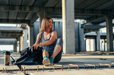 Koşuya hazırlanıyor gülümseyen bir sporcu kadın görüntüsünü.