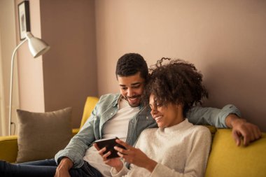 Afrika kökenli Amerikalı çift tablet üzerinde zaman online harcama.