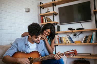 Şarkı ve evde gitar çalmak Afrikalı-Amerikalı çiftin fotoğraf.