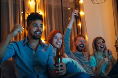 Mutlu arkadaş evde televizyonun önünde tezahürat atış.