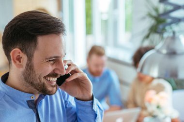 Cep telefonuyla konuşan genç bir adam portresi.