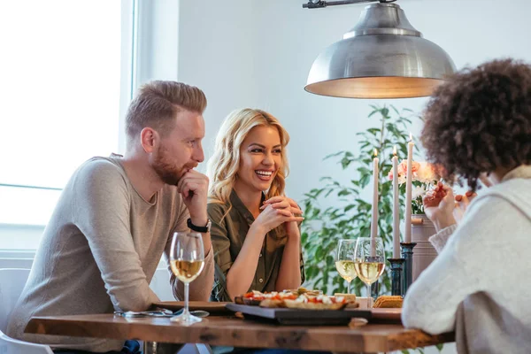 Shot of young couple having a good time with friends over dinner.