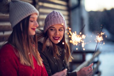 Kışın köpüklü sopa tutan iki güzel genç kadın portresi.