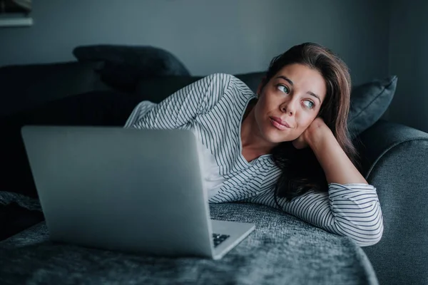 Mujer Joven Acostada Sofá Utilizando Ordenador Portátil —  Fotos de Stock