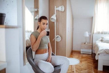 Güzel genç bayan evde kahve içiyor..