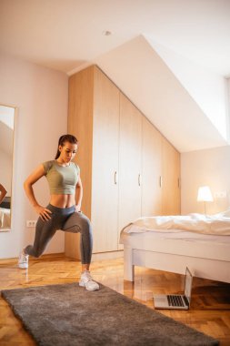 Sportif kız evde egzersizleri yapıyor.