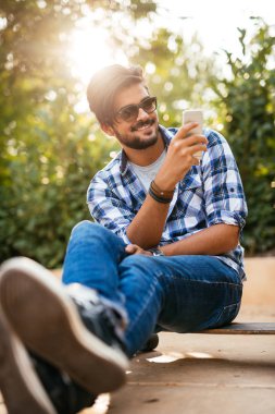 Mutlu, rahat genç adam manifatura telefon.