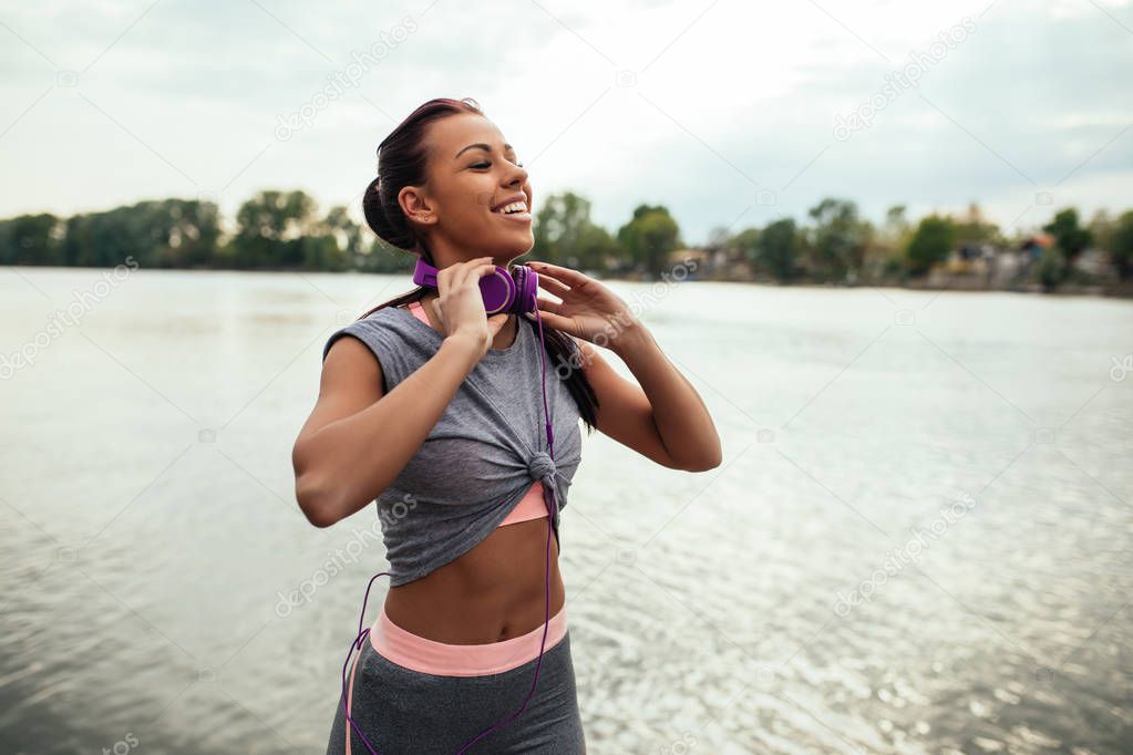 Photo of an athlete woman enjoying listening to music outdoors.