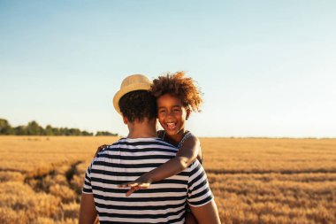 Atış bir Afro-Amerikan baba ve kızı tarlada sarılma.