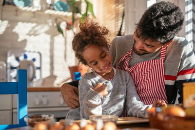 Baba ve kızı mutfakta birlikte yemek pişiriyorlar..