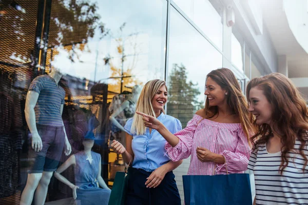 Üç güzel bayanı pencere alışveriş fotoğraf.