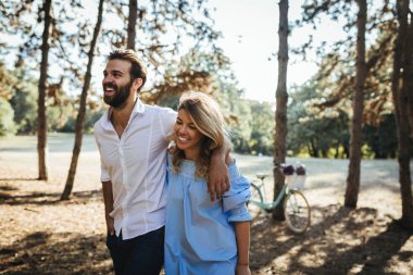 Mutlu çift ormanda yürürken sarılma.