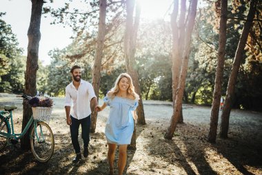 Mutlu çift ormanda yürürken elele.