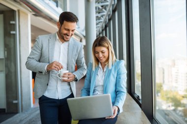 Atış iki mutlu meslektaşlarının çalışmaları sırasında dizüstü kullanarak ve kahve içme konusunda konuşurken.