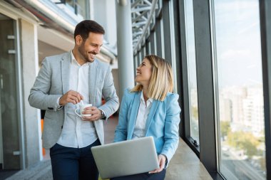 Birlikte kahve içme ve dizüstü kullanarak çalışan iki mutlu meslektaşlarının atış.