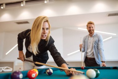 Kadın meslektaşı ile ofiste bilardo oynarken.