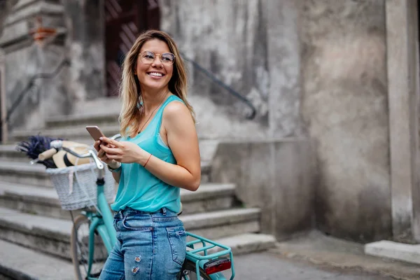 Portret Pięknej Kobiety Rowerem Stojący Zewnątrz Przy Użyciu Telefonu Komórkowego — Zdjęcie stockowe