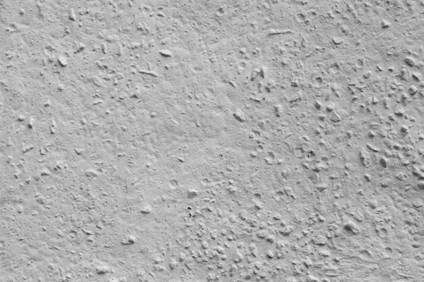 Beton duvar taşlarla beyaza boyanmış.