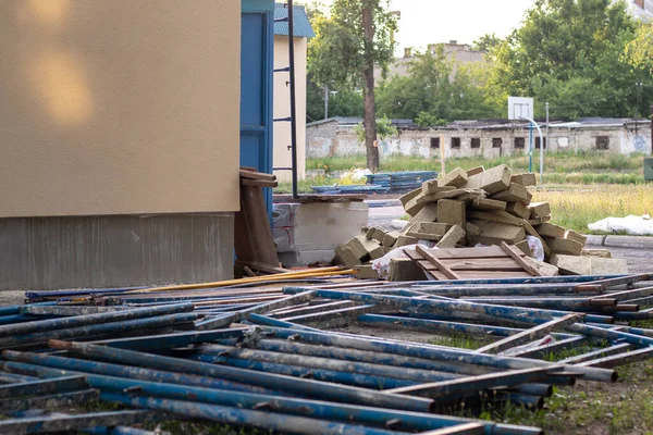 A white brick building surrounded by scaffolding is insulated with brown insulating material.