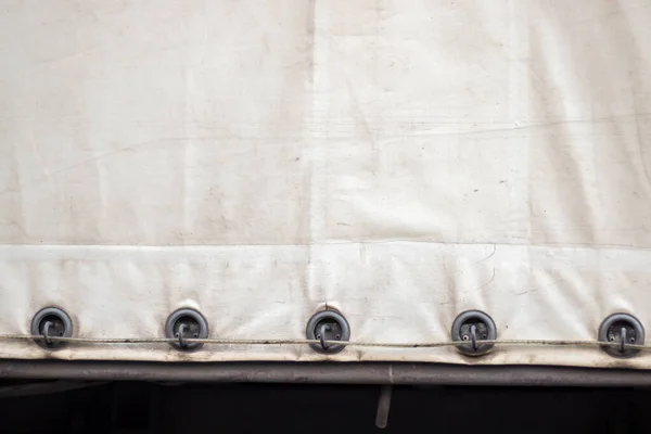 Kamyonda gri renkte eski bir tente..