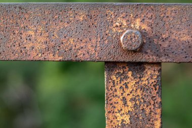 Paslı bir cıvatayla tutturulmuş paslı metal köşeler. Yakın plan..