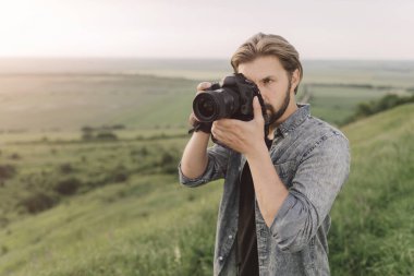 Tepedeki dijital kamerayı kullanarak deneyimli seyahat fotoğrafçısı