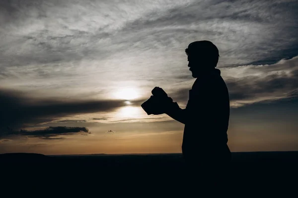 Baard man in silhouet beoordelen van gemaakte foto 's op camera — Stockfoto