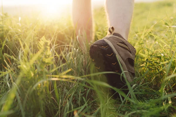 Close up of hiker in special shoes walking on grass