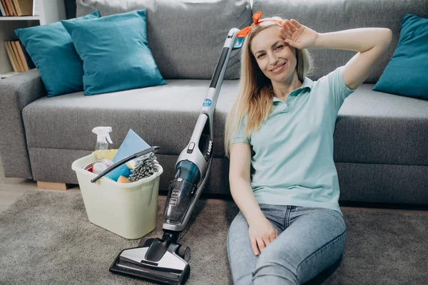 Müde Frau entspannt sich auf dem Fußboden nach dem Putzen der eigenen Wohnung — Stockfoto