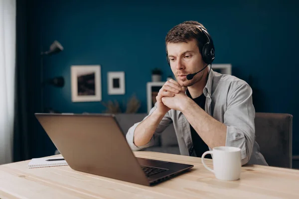 Hombre confiado con auriculares durante el chat de vídeo en el ordenador portátil — Foto de Stock
