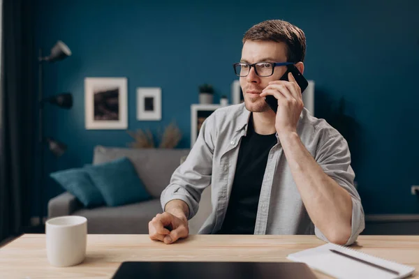 Fešák mluví na mobilním telefonu, zatímco zůstává doma — Stock fotografie