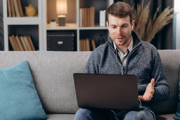 Freelancer masculino em fones de ouvido com chat de vídeo no laptop — Fotografia de Stock