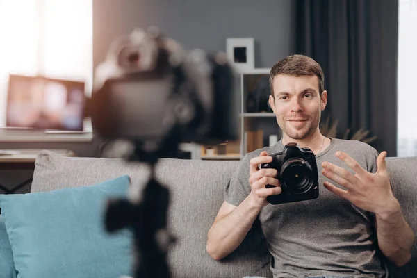 Young bearded man doing video review of new digital camera — Stock Photo, Image