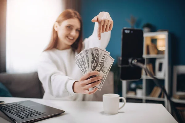 Mujer sonriente sosteniendo dinero y grabando video para blog — Foto de Stock