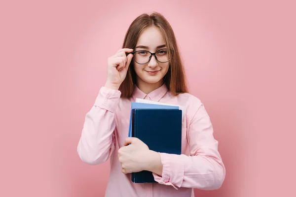 Attraktives Mädchen hält Bücher in der Hand und blickt in die Kamera — Stockfoto