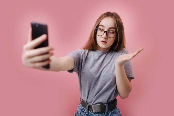 Blondă surprinsă folosind smartphone-ul pentru video chat în studio — Fotografie, imagine de stoc