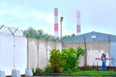 Endüstriyel bölgenin üzerinde asılı duran doldurulmuş bir korkuluk.