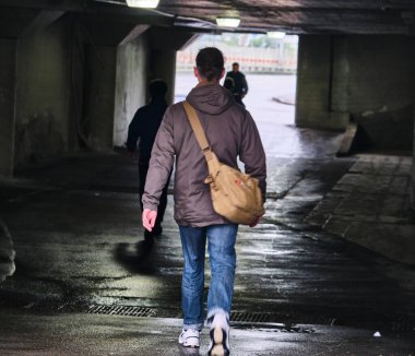 İnsanlar karanlık bir tünelde, düşük ışıkta, genel planda.