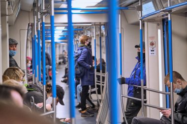 Rusya Haziran 2020. Moskova metrosu. Koruyucu maskeli insanlar metro vagonuna binerler. Rusya 'da koronavirüs salgını. Virüs bulaşma riski var. renk