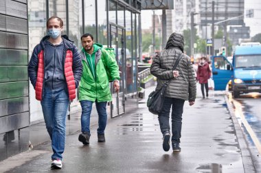Rusya 2020 Haziran 'ında Rusya' da koronavirüs salgını sırasında tıbbi maskeli insanlar kaldırımda yürür. renk