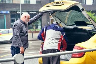 Rusya 2020 Haziran 'ında, taksi şoförü müşteriyle olan güvenli sosyal mesafeyi ihlal etti ve kişisel koruyucu giysi giymedi. Rusya 'da koronovirüs salgını, enfeksiyon riski. renk