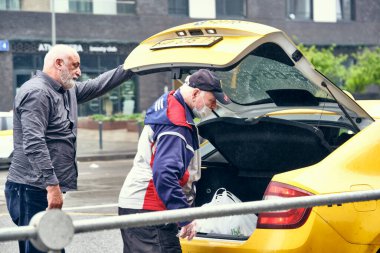 Rusya 2020 Haziran 'ında, taksi şoförü müşteriyle olan güvenli sosyal mesafeyi ihlal etti ve kişisel koruyucu giysi giymedi. Rusya 'da koronovirüs salgını, enfeksiyon riski. renk